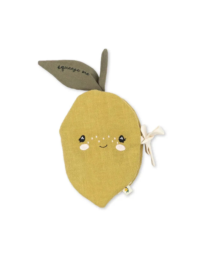 The Konges Sloejd Fabric Lemon Book is a soft, lemon-shaped yellow pouch with a smiling embroidered face, two green leaves—one reads "squeeze me"—and a beige ribbon on the side. Perfect early sensory toy for little ones.
