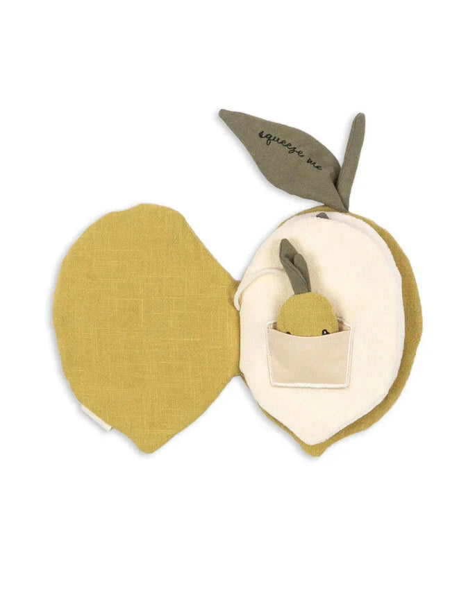 The Konges Sloejd Fabric Lemon Book is a soft, fabric lemon that opens like a book to reveal a pocket with a tiny plush toy inside. A green leaf labeled "squeeze me" adds charm, making it an adorable early sensory toy for babies.