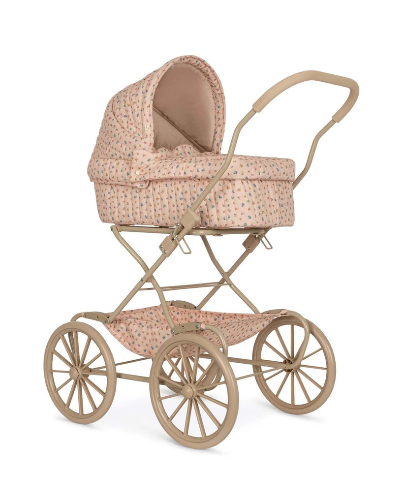 Introducing the Doll Pram - Boomie Blush: a vintage-style baby stroller beautifully crafted using recycled materials with a charming floral patterned fabric. This elegant stroller is designed with a beige frame, featuring four large spoked wheels and a stylish curved handlebar. It also includes an enclosed, cushioned bassinet to ensure comfort for your little one.