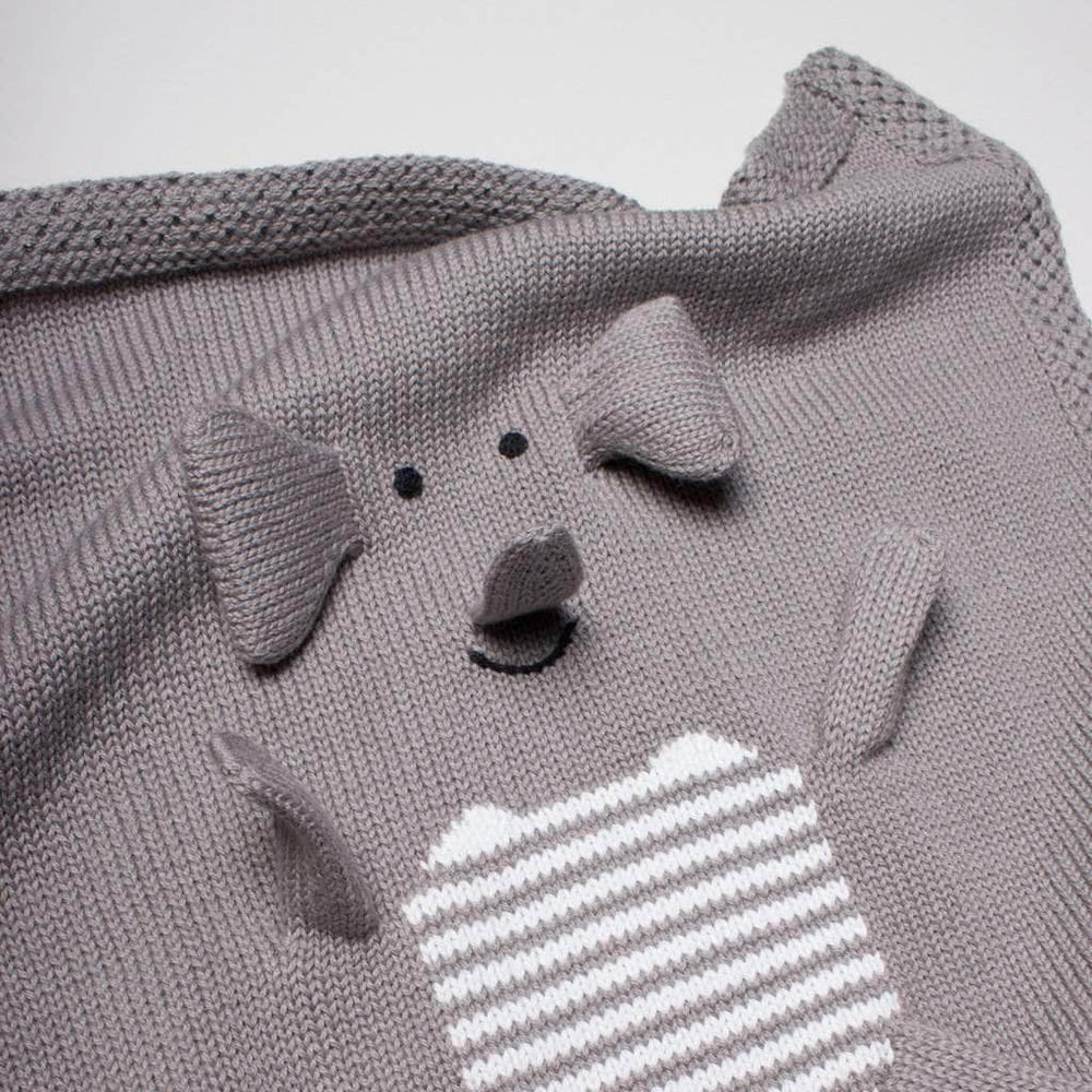 Gray knitted Organic Baby Lovey Blanket - Elephant crafted from organic cotton, featuring a playful design with a three-dimensional dog face and ears popping out from the upper left, and a white and gray striped patch resembling a pocket on the.