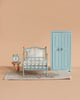 The Maileg Bedroom Set features a vintage bed, matching blue wardrobe, floral rug, alarm clock, and wooden stool—an adorable mouse furniture collection displayed against a soft beige background.