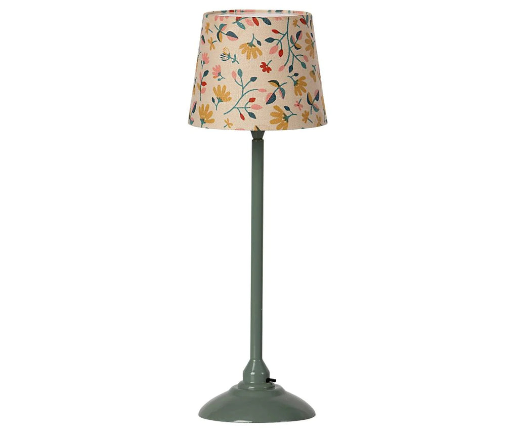 A table lamp with a floral patterned shade in pastel colors and a sleek, muted green base designed with various small leaves, flowers, and Maileg Living Room Starter Set.