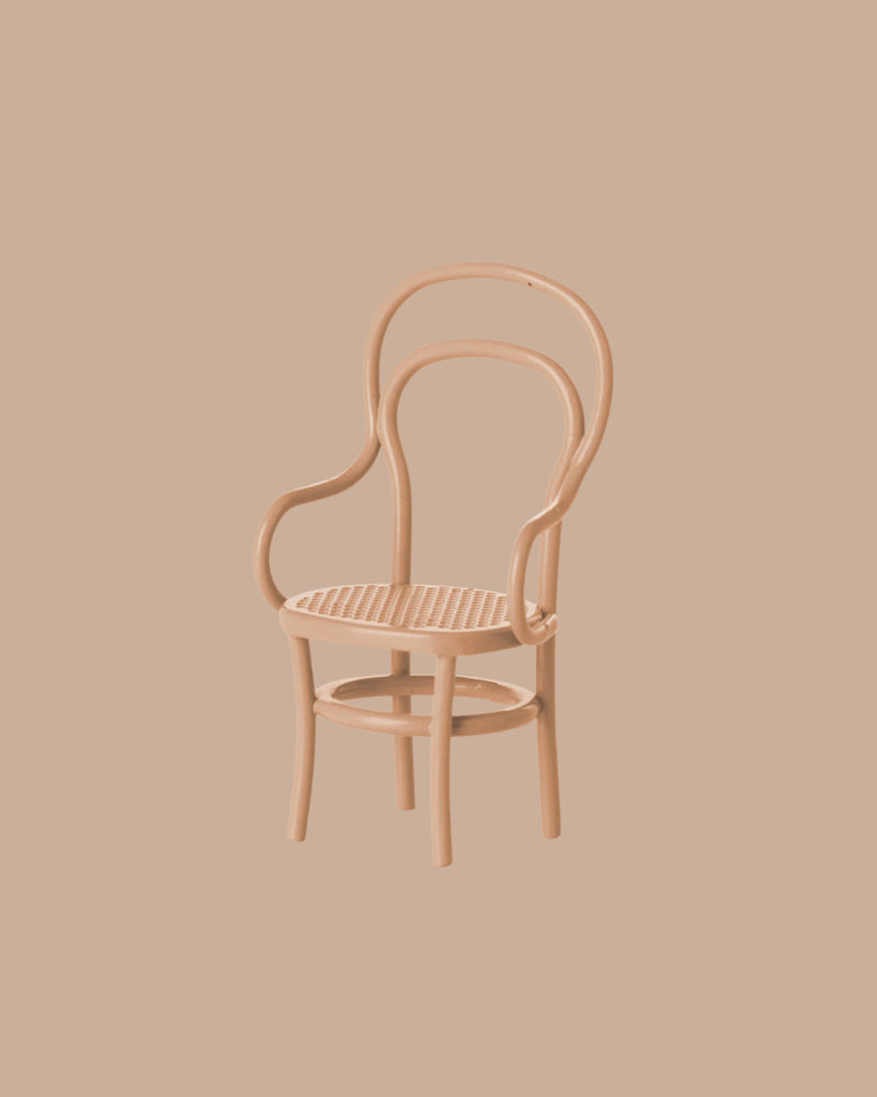 A charming light brown, curved-back wooden chair with a woven seat from the Maileg Kitchen Set, ideal for Maileg mouse furniture, is displayed against a matching beige background.