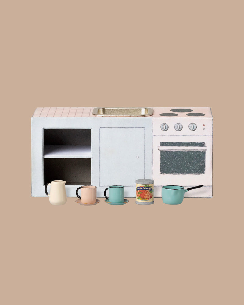 The Maileg Fully Furnished SuitCasa is a small toy kitchen set with a stove, oven, sink, shelves, four mini cups, pitcher, tomato can, and kitchen accessories—perfect for any mouse house and displayed on a plain beige background.