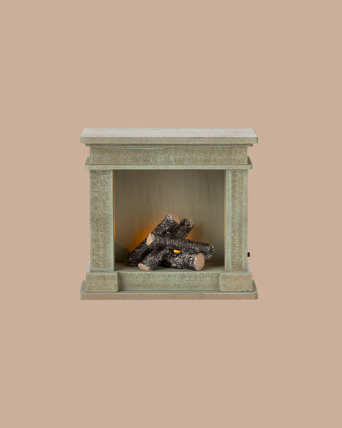 PRE-ORDER: Fireplace, Miniature – Dusty Green (ships early October), features a small rectangular shape with vintage finish and artificial logs; perfect for adding charm to any miniature home. Set against a plain beige background.