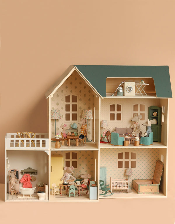 The Maileg Fully Furnished Dollhouse Set + Surprise Gift features six rooms with miniature furniture and mouse dolls in playful scenes, all set against a soft beige background.