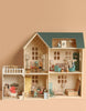 The Maileg Fully Furnished Dollhouse Set + Surprise Gift features six rooms with miniature furniture and mouse dolls in playful scenes, all set against a soft beige background.
