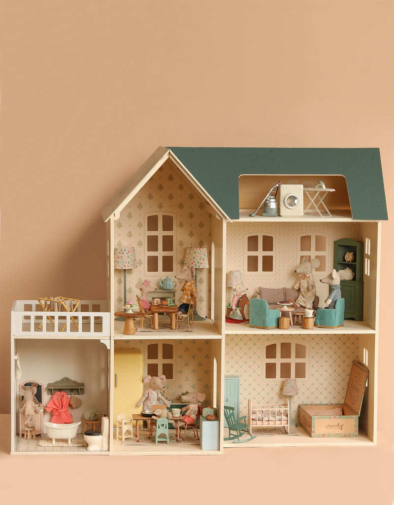 The Maileg Fully Furnished Dollhouse Set + Surprise Gift features six rooms with miniature furniture and mouse dolls in playful scenes, all set against a soft beige background.