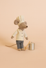 The Maileg Pastry Chef Set with Grapat Wooden Bake Set features a chef mouse in white hat and jacket, checkered pants, holding a wooden spoon, standing by a silver pot—ideal for pairing with Miniature Cakes on a beige background.