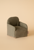 The Maileg Folding Chair, Mouse - Green Checker features a small green and beige checkered design, short arms, and a fabric tag. Ideal for dollhouse accessories or Gingerbread House furniture. Shown on a light beige background.