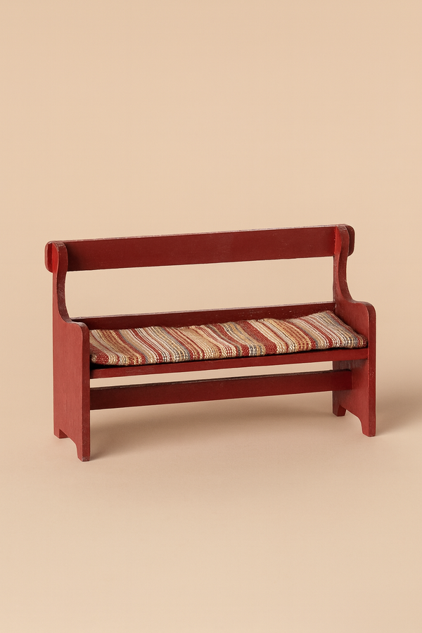 The Maileg Mouse Bench - Red is a small, hand-painted wooden bench with armrests and a backrest, featuring a striped cushion in beige, red, and green—ideal as charming mouse furniture—set against a plain beige background.