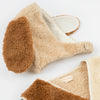 The Meri Meri Puppy Costume - Final Sale is a cozy beige and brown faux shearling hat designed to resemble dog ears, perfect for a puppy costume or as a gift for dog lovers. The hat features floppy brown ears and is lined with soft white sherpa fleece. Inside, there's a label that reads "Max Mara." The hat is laid flat on a white background.