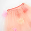 A close-up of the Meri Meri Flower Cape, featuring peach tulle with a pink trim and pastel pink and cream flower appliqués—perfect for floral dress-up or as a charming accessory for a flower-themed costume.