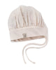 A pale beige Milton & Goose Chef's Hat with ruched detailing and a small embroidered logo on the front band, featuring two thin straps for tying under the chin, displayed on a white background.