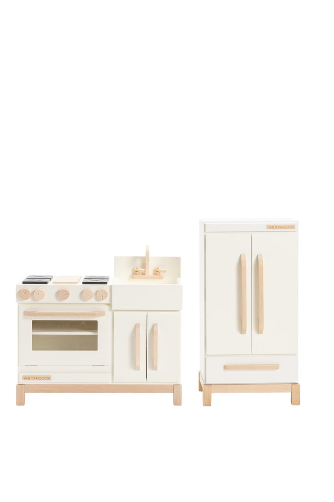 The Milton & Goose Essential Play Refrigerator, made in the USA, features a stylish white finish with natural wood accents—perfect for imaginative play and pairing with play food, shown against a plain white background.