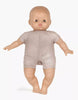 A Minikane Soft Body Doll (11") - Jasper with a bald head and round face is standing upright. It is wearing a simple, short-sleeved, silver-grey outfit that covers the torso and upper legs. Made from phthalate-free vinyl, this bedtime companion has its arms slightly spread out and stands barefoot on a plain background.