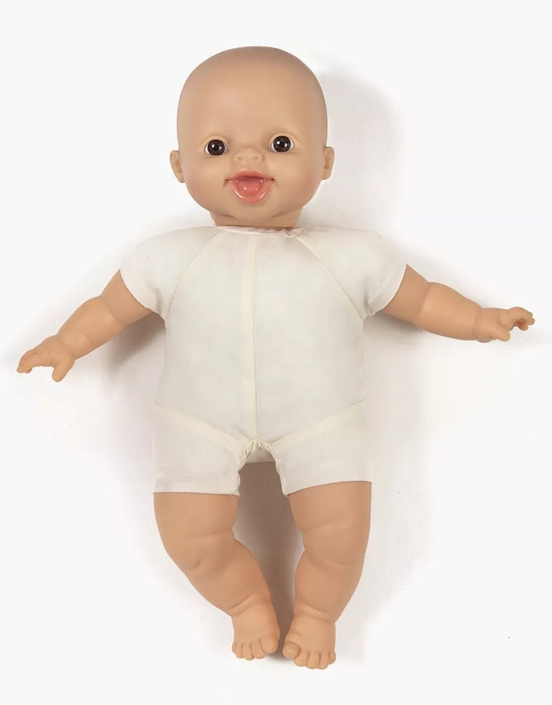 A Minikane Soft Body Doll (11") - Léo with a bald head and large, expressive eyes is dressed in a short-sleeve, onesie-like white outfit. The doll has a slight smile and open mouth, with its arms and legs slightly spread—perfect for imaginative playtime or as a bedtime companion against the plain white background.