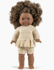 A Minikane Doll Clothing | Vito Shorts in Cream Knit with dark brown curly hair, brown skin, and brown eyes is dressed in a beige knit top with a peplum hem and matching shorts. The doll stands upright against a plain white background.