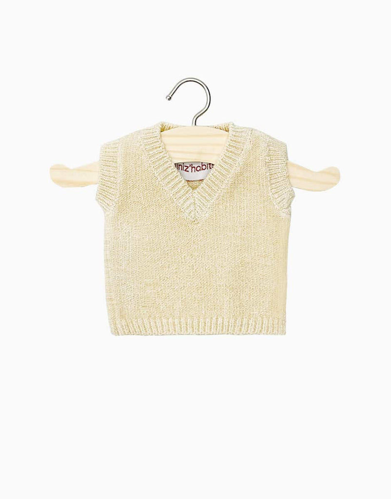 A cream knit Leonardo tank top, designed for Minikane babies and dolls, is showcased on a wooden hanger against a simple white background.