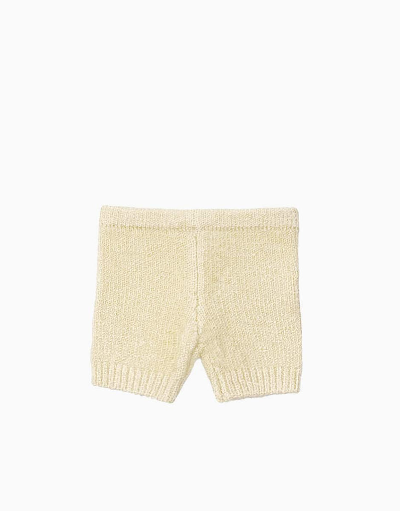 Image of a pair of beige, ribbed knit baby shorts with an elastic waistband and a snug fit, perfect for Minikane Babies. The shorts are displayed flat on a plain white background. These are the Minikane Doll Clothing | Vito Shorts in Cream Knit.