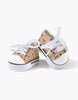 A pair of small, stylish Converse-style gold sequin sneakers from Minikane Doll Clothing, featuring a light brown background with white polka dots, white toe caps, and traditional laces. The sneakers have a white rubber sole with a black stripe and are positioned on a plain white background.