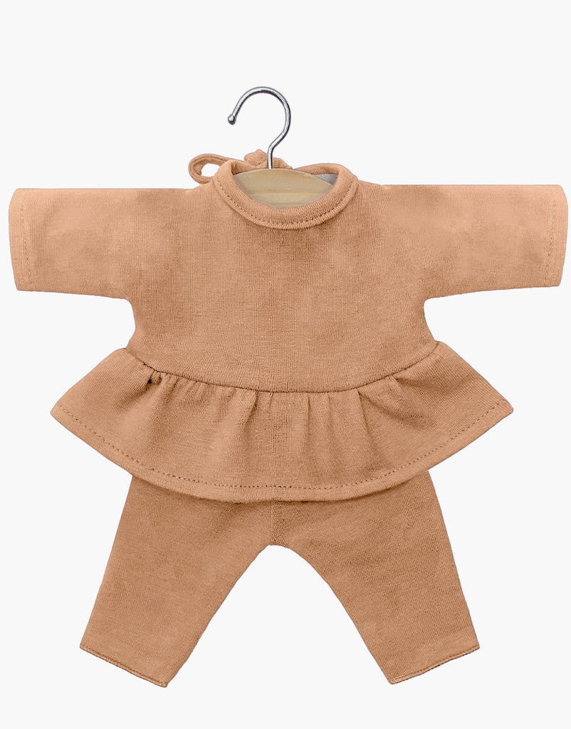 A Minikane Clothing | Ophélia Set in Brown Sugar with a round neckline and a ruffled hem, paired with matching pants, displayed on a small hanger against a white background. Made from cotton hand washable material, this outfit offers both style and practicality for Minikane Babies dolls.