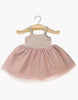 The Minikane Doll Clothing | Rosella Tutu - Pink features a sleeveless beige knit bodice and a light pink tulle skirt, designed in France and shown on a wooden hanger against a white background.