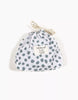 A small white drawstring pouch with blue polka dots, designed for Minikane 13" Doll Clothing—Lou Retro Romper with Headband in Cotton. The front label reads “minikane LOU, set gourde, THELMA.” Slightly gathered at the top.