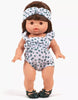 A 13" Minikane doll wears the Lou Retro Romper with Headband in cotton polka dot, paired with dark green sandals. The brown-haired doll stands facing forward against a plain white background.