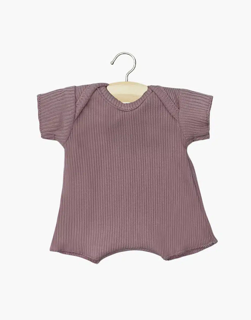 The Minikane 11" Dark Orchid Ribbed Body Shorty, a charming pink ribbed baby romper with short sleeves, is showcased on a wooden hanger against a crisp white background, highlighting its French craftsmanship.