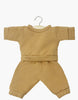 The Minikane Doll Clothing | Liam Havana Fleece Set is a small beige two-piece outfit featuring a long-sleeve top and matching pants. Hand washable and crafted with care in France, this elegant ensemble is displayed on a wooden hanger against a pristine white background.