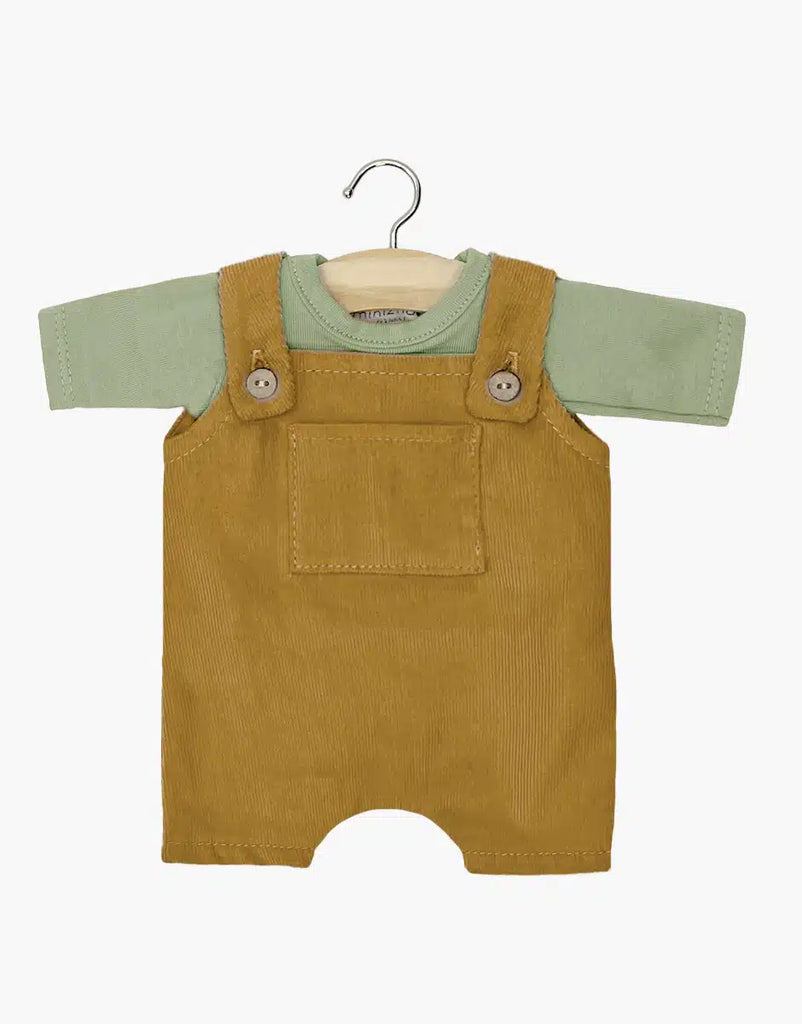 Baby outfit on hanger: green jersey short-sleeve T-shirt under khaki-colored overalls set with a front pocket and button straps, crafted from soft cotton by Minikane Doll Clothing.