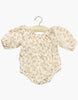 The Minikane Doll Clothing Cotton Bertille Romper - Feline features puffed sleeves and elastic leg openings in a light beige and tan leopard print. Made in France, this hand-washable romper is perfect for stylish comfort. Presented on a wooden hanger.