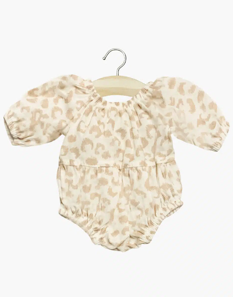 The Minikane Doll Clothing Cotton Bertille Romper - Feline features puffed sleeves and elastic leg openings in a light beige and tan leopard print. Made in France, this hand-washable romper is perfect for stylish comfort. Presented on a wooden hanger.