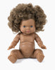 A brown-skinned Minikane Baby Doll (13") - Charlie with curly, light brown hair is sitting upright with its legs spread apart and arms extended forward. The anatomically correct doll has blue eyes and a slight smile, and is undressed against a plain white background.