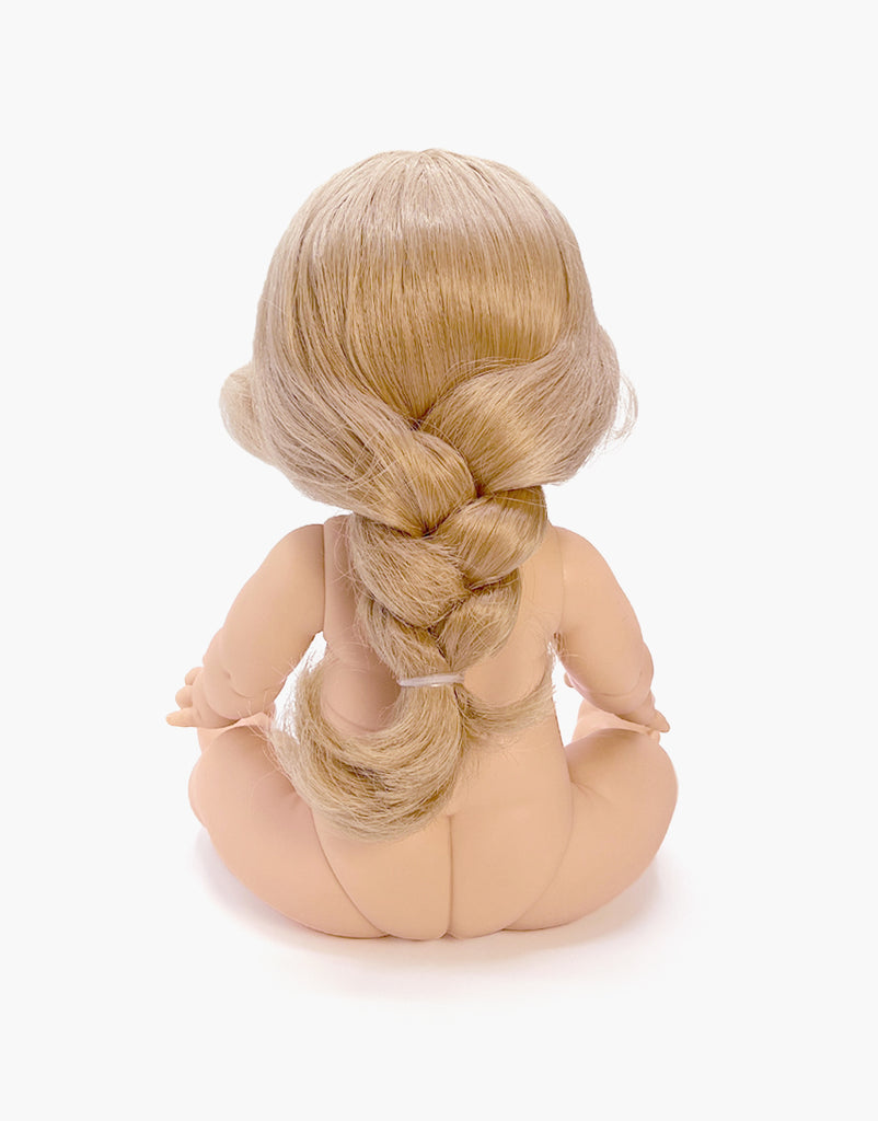 The Minikane Baby Doll (13") - Eleanor is depicted from the back, sitting with legs outstretched on a white background. Her long, light blonde hair flows elegantly in a loose braid down her back, enhanced by a gentle vanilla scent.