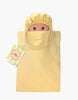 The Mini Pancha Doll - Basile with Green Striped Bath Set features a wide-eyed Paola Reina doll tucked inside a coordinating green striped fabric bag. A colorful tag is attached to the bag’s handle, making it perfect for imaginative play. The scene is set against a plain white background.