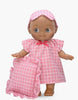 The Mini Pancha Doll - Maia with Pink Checkered Nightgown stands against a white background, wearing a charming pink checkered nightgown and matching sleep mask while holding a ruffled pink checkered pillow—perfect for imaginative play.