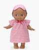 The Mini Pancha Doll - Maia with Pink Checkered Nightgown features big eyes, high-quality vinyl construction, and comes dressed in a pink checkered nightgown with a matching headband. She stands barefoot with arms slightly outstretched against a plain white background—perfect for hours of imaginative play.