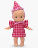 Minikane Mini Pancha Doll - Ninon Celebrating with Cherry Gingham Outfit, wearing a pink cherry-patterned gingham dress with ruffled sleeves and a matching party hat with a frilled edge, perfect for imaginative play.