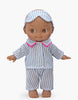 The Minikane Mini Pancha Doll - Noah features blue and white striped pajamas with pink trim and a matching sleep mask, standing barefoot against a plain white background—perfect for imaginative play.