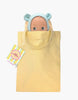 A high-quality vinyl Minikane Mini Pancha Doll - Zebulon dressed in a mint blue mouse outfit peeks out of a yellow cloth tote bag. A colorful tag is attached to the handle, inviting imaginative play. The background is white.