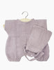 A baby outfit on a hanger, featuring a light purple, long-sleeved romper with elasticated cuffs and ankles, paired with matching pants. The double gauze set fabric appears soft and textured, likely made from a comfortable, breathable material perfect for Minikane Clothing | Romper and Bonnet Set or 11" dolls.