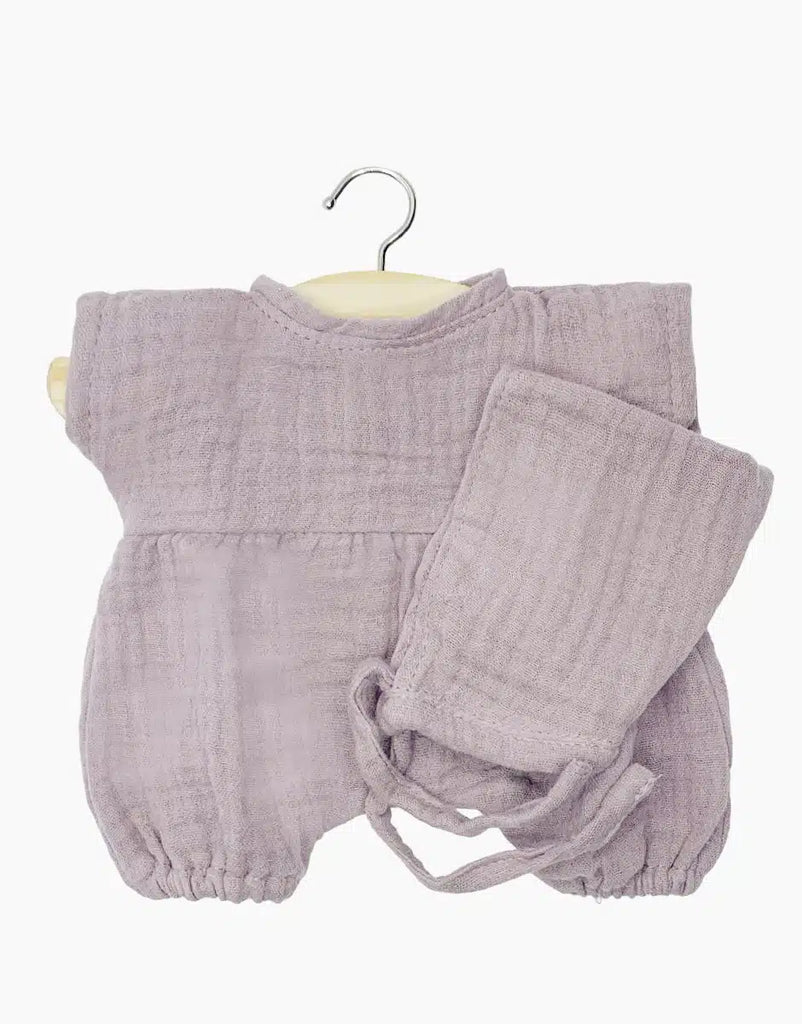 A baby outfit on a hanger, featuring a light purple, long-sleeved romper with elasticated cuffs and ankles, paired with matching pants. The double gauze set fabric appears soft and textured, likely made from a comfortable, breathable material perfect for Minikane Clothing | Romper and Bonnet Set or 11" dolls.