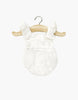 The Minikane 13" Doll Clothing | Lou Retro Romper in Cotton Gauze - Cream, featuring ruffled straps and soft double gauze, hangs on a wooden hanger against a plain white background.