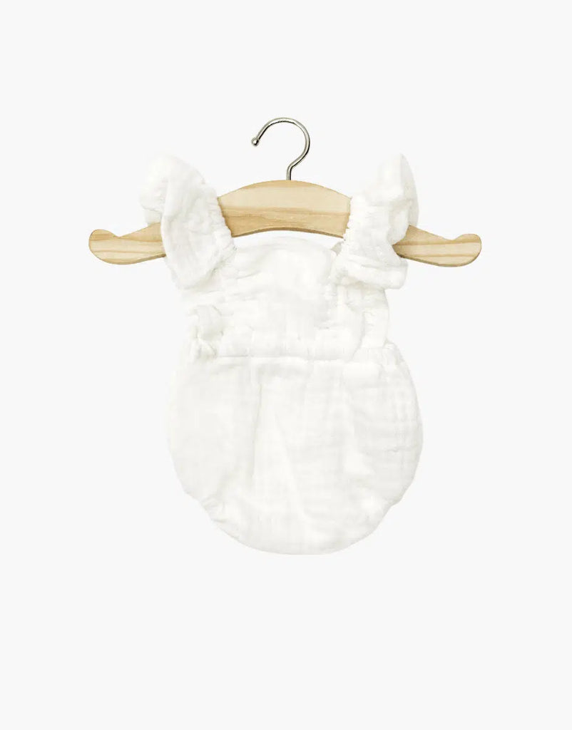 The Minikane 13" Doll Clothing | Lou Retro Romper in Cotton Gauze - Cream, featuring ruffled straps and soft double gauze, hangs on a wooden hanger against a plain white background.