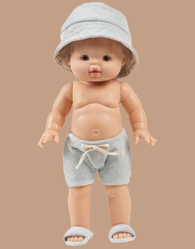A Minikane doll models the Emile & Ida Sun 3-piece Swimsuit Set in Terrycloth - Green Tea, standing against a plain beige background.