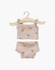The Minikane Doll Clothing | Les P'tits Basiques 2-piece set in ribbed cotton features a pink hearts tank top and ruffled shorts, displayed on a small wooden hanger—perfect underwear for Minikane dolls.