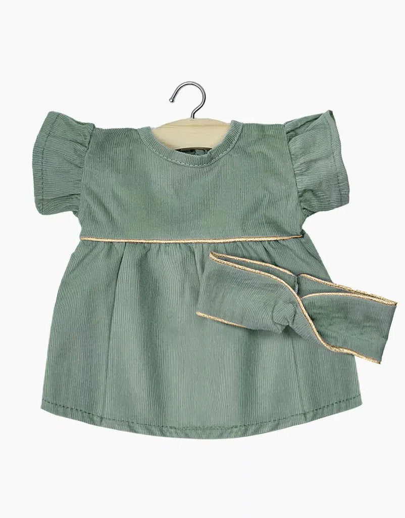 The Minikane Doll Clothing, Daisy Dress with Headband in Sage Green features a corduroy baby dress with puffy short sleeves and a matching headband, designed in France. Hand washable and displayed on a hanger against a white background, it perfectly coordinates style and practicality for Minikane dolls.