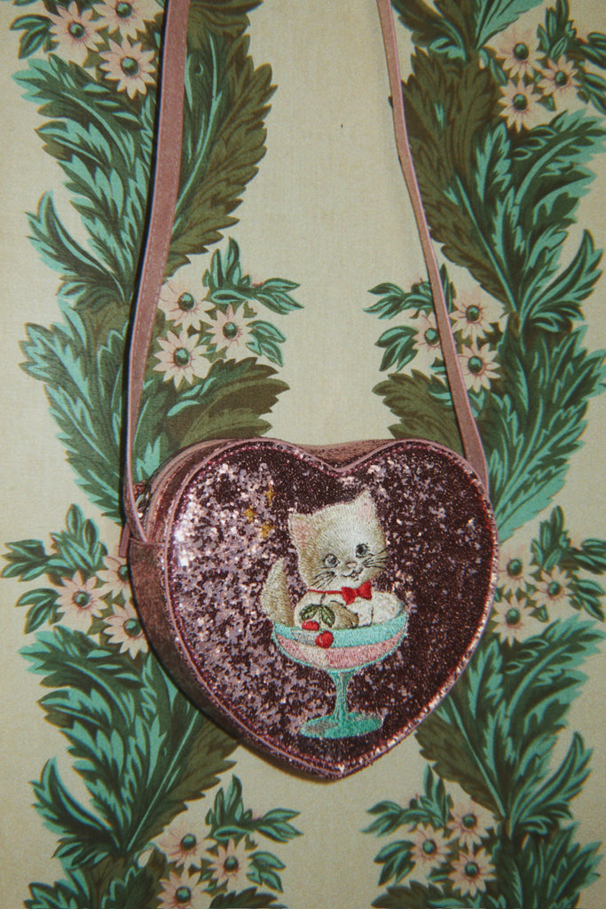 Konges Sloejd Tut Kitty Shoulder Bag in glittery pink, shaped like a heart and featuring an embroidered kitten sitting in a dessert glass.